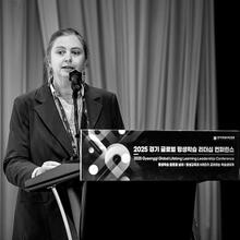 A woman stands at a conference lectern